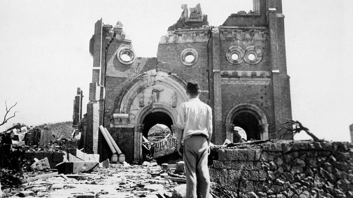 Urakami e a Bomba Atômica: História, Catedral e Impacto Ruínas de uma igreja em Hiroshima após o bombardeio atômico de 1945, com um homem caminhando entre os escombros.