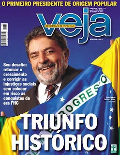 Capa da revista Veja mostrando Luiz Inácio Lula da Silva sorridente, coberto pela bandeira do Brasil, com a manchete "Triunfo Histórico".